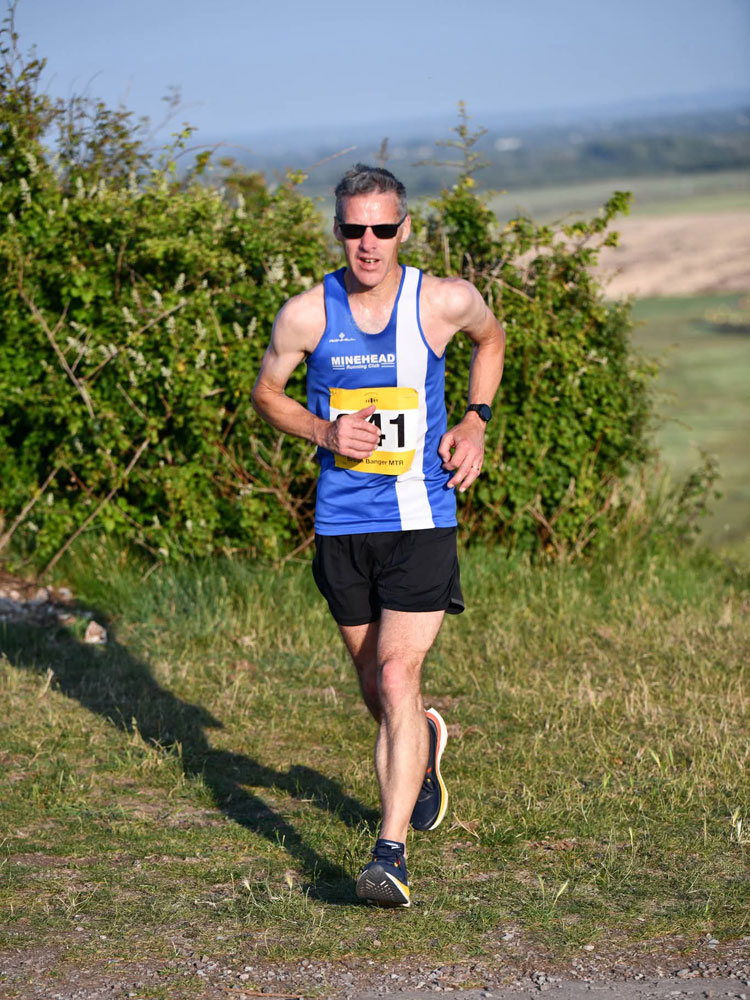 A member of Minehead Running Club running near the coast