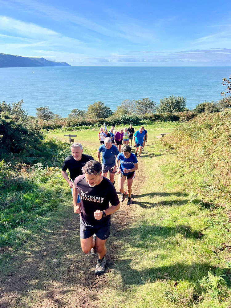 Members of Minehead running club running along a trail near the coast