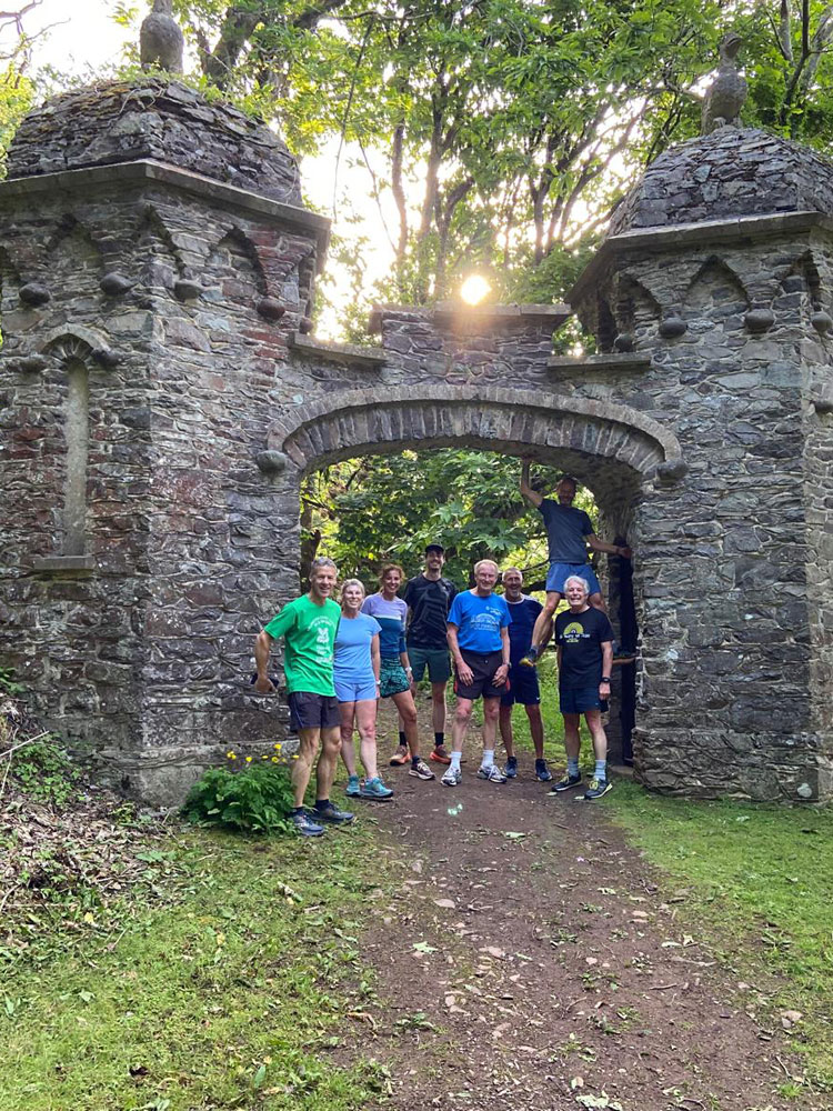 Members of Minehead running club stopping next to a feature on the SW Coast Path